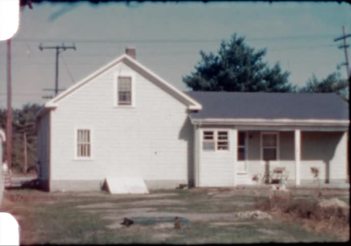 A woman walks into the back yard of a small New England home in the 1950's