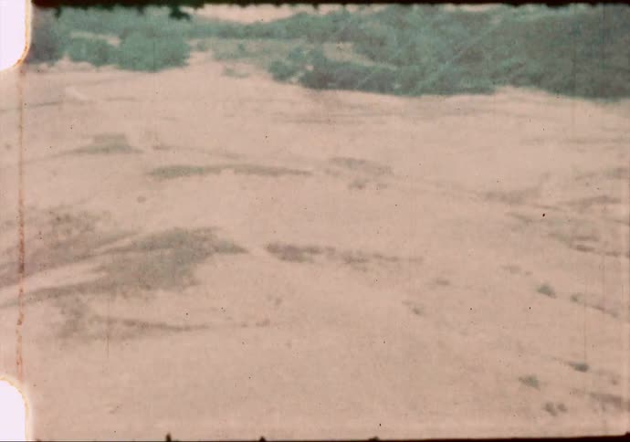 Dry grasslands line the hill country in the western United States in the 1960's