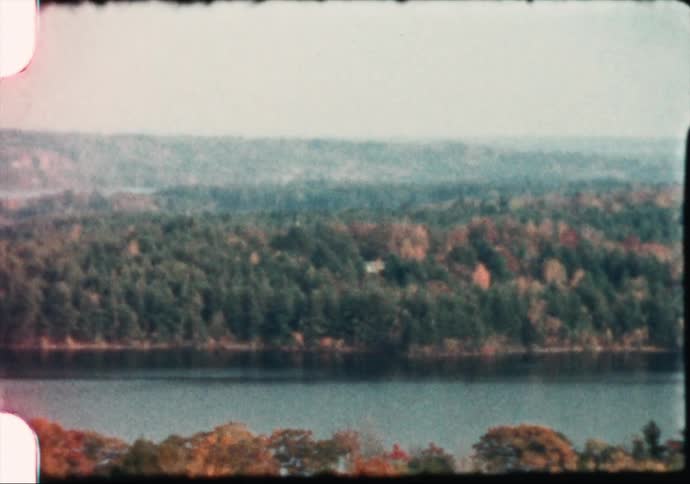 A lake surrounded by trees covered in fall foliage in the daytime