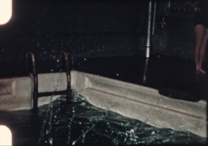 Women practice diving into a swimming pool in the 1960's