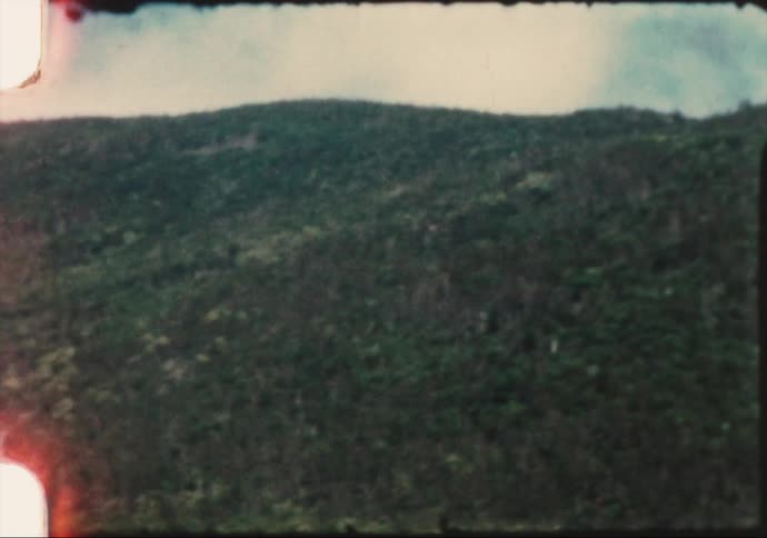 Green vegetation on the mountains caught on yellowing vintage film