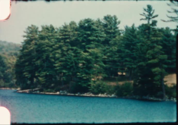 A hotel sitting on a hill overlooks a Maine lake