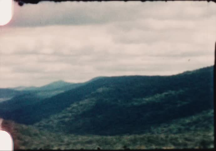 Clouds floating above tree covered mountains in nature