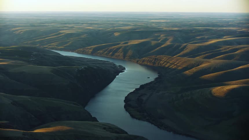 Awesome sunset aerial of the glimmering Lower Snake River in Eastern Washington as it weaves through the Palouse high country