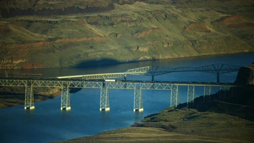 A long cargo train travels across Central Ferry Bridge also known as Elmer C. Huntley Bridge spanning the Lower Snake river in eastern Washington