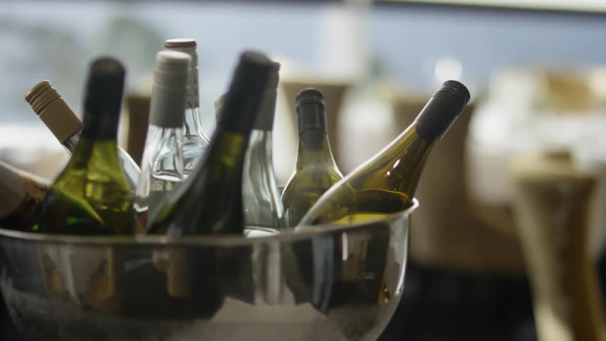 Wine bottles fill a silver bowl