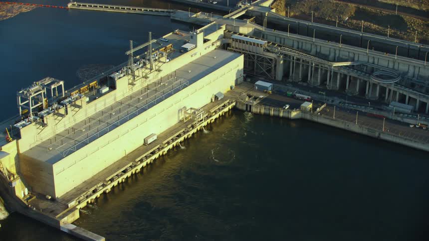 Little Goose Dam on the Lower Snake River in this low altitude dynamic aerial shot of the impoundment in golden hour light