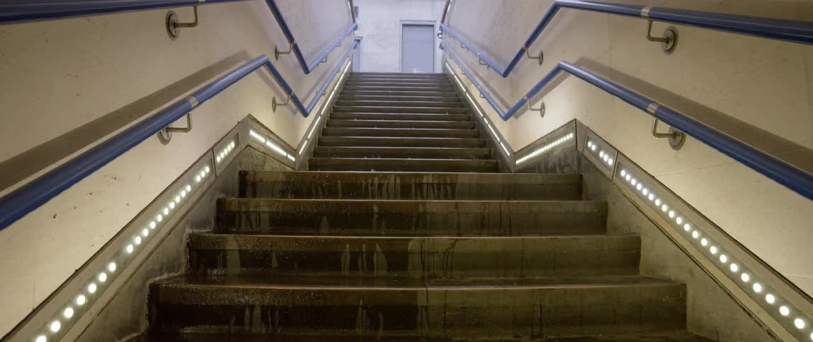 View of stair climbing to an opening above while the rain is falling