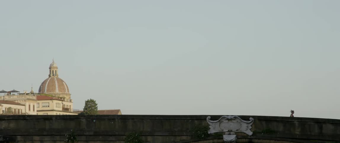 Ponytailed woman jogging across a bridge on a clear day