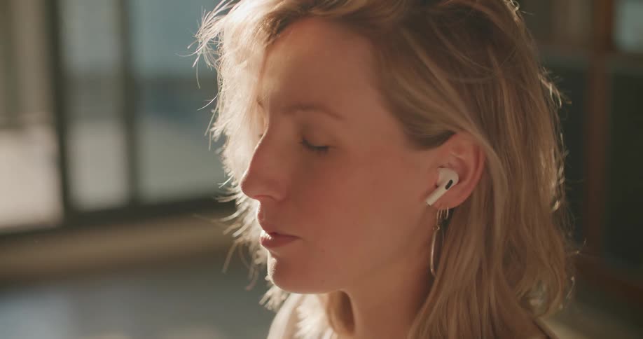 A woman sitting on a floor with headphones in