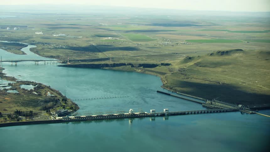 McNary Locke and Dam is visible in the foreground with I-82 in the background in this wide aerial of the Lower Columbia River Dam network