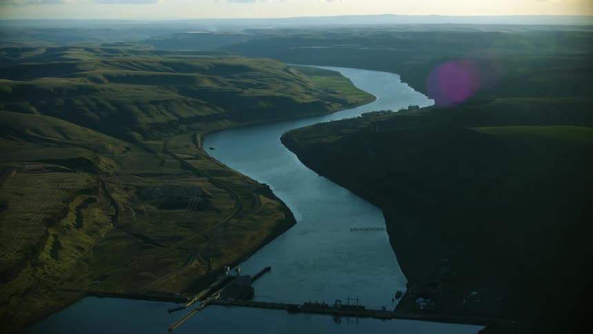 Looking downstream on the Lower Snake River in Eastern Washington with Lower Monumental dam in the foreground showing how dams block the free flowing water in this river