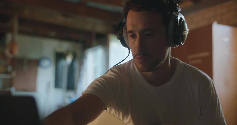 Musician wearing headphones playing electric guitar in the studio