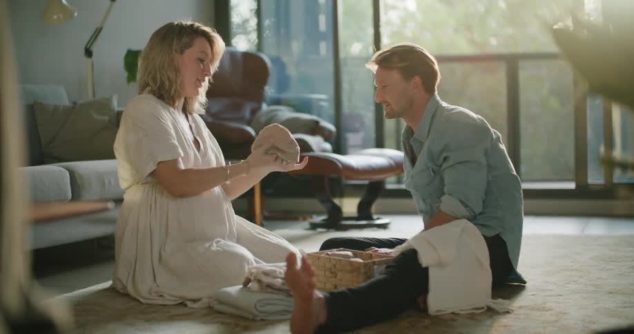 A man and woman are sitting indoors and talking