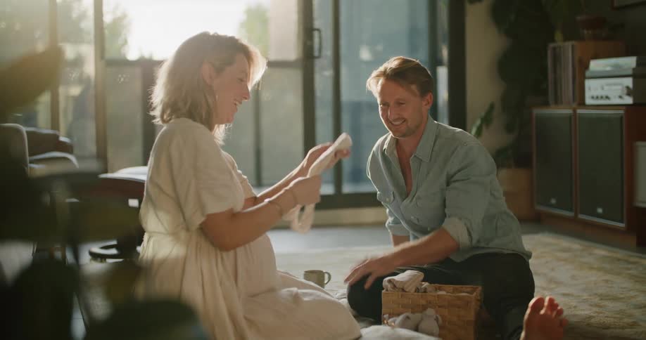 A mother and father are looking at clothes in a room