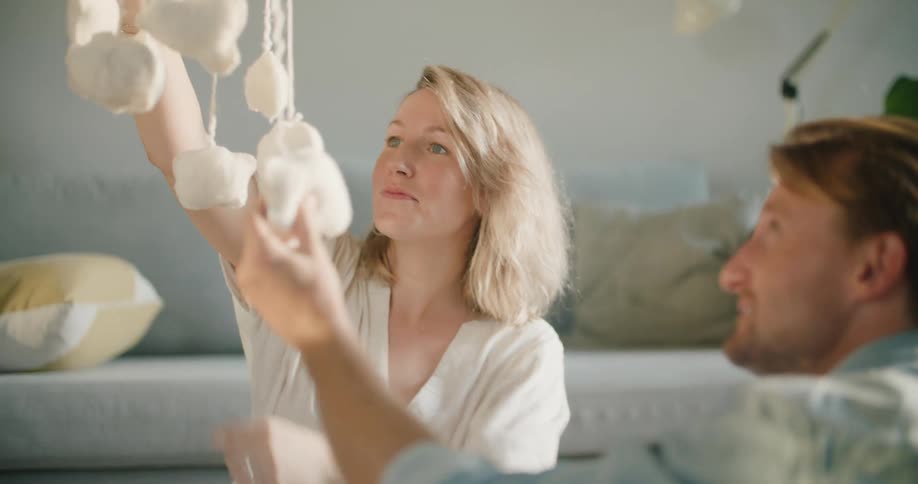 A woman hangs a toy in the air