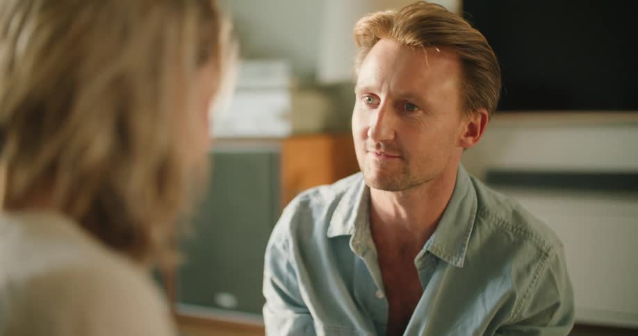 A man reaches out his arm as he talks to a woman