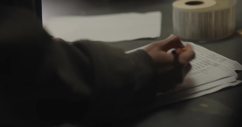 An employee writing on a piece of paper with a pencil