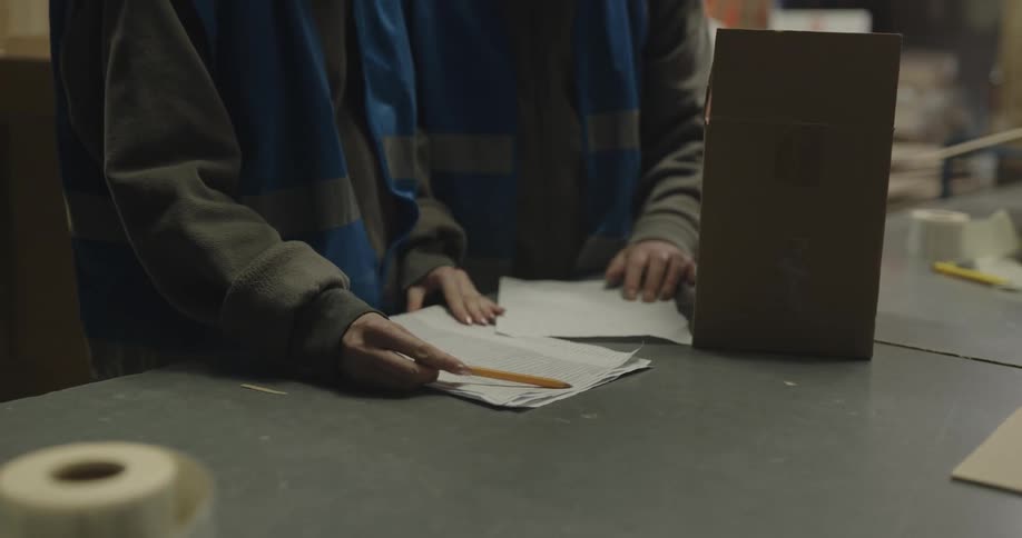 Male and female coworkers check inventory in warehouse