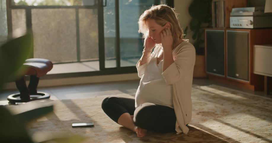 A woman sitting on the ground with headphones in