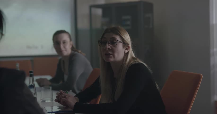Group of people talking on a meeting in an office with a bit display on the wall