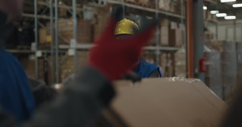 Two employees boxing things up in a warehouse