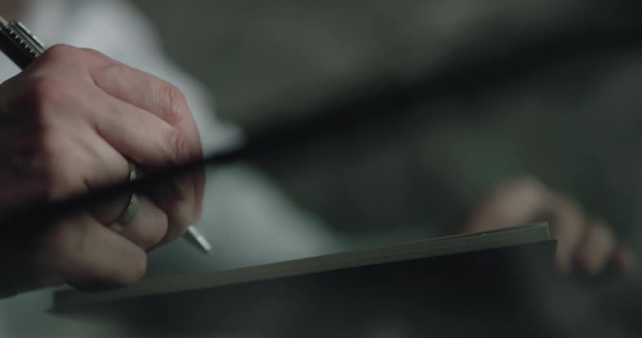 A person turning pages in a book to write in it with a pen