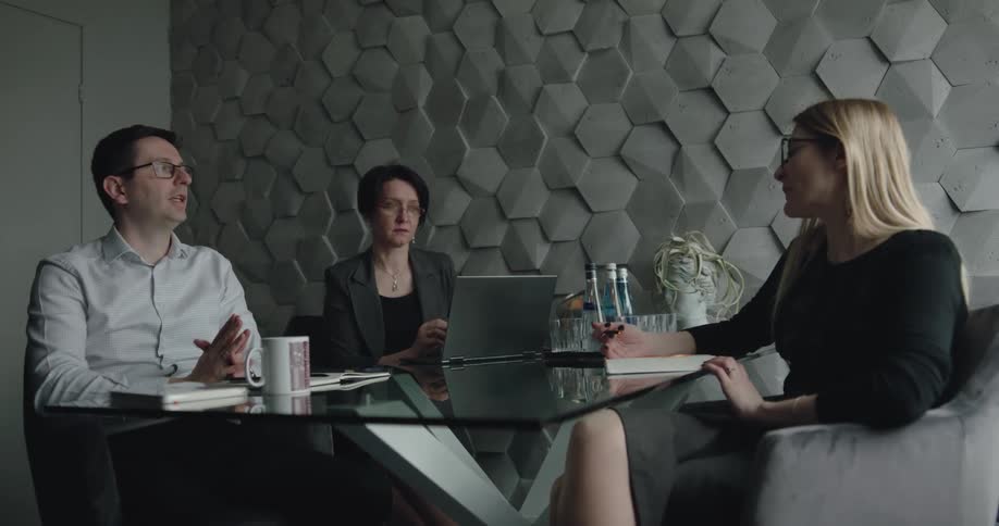 Three coworkers are talking together in an office