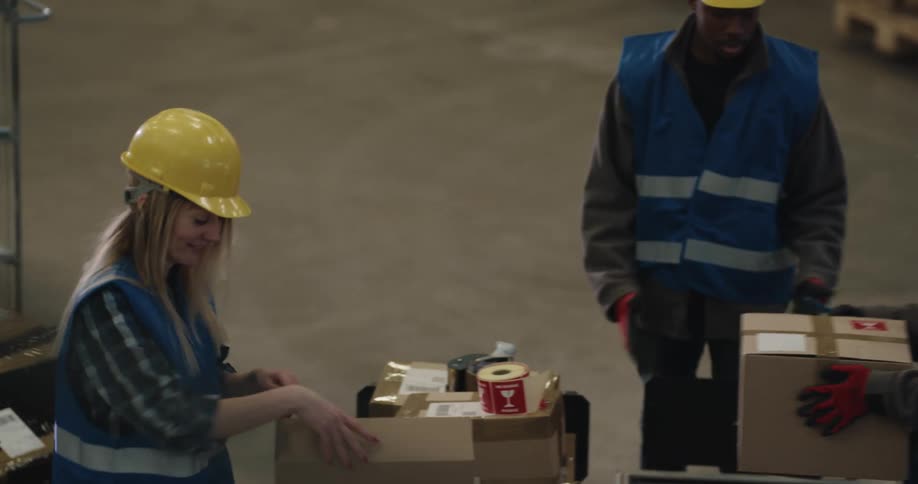 Workers in a warehouse packing products in cardboard boxes