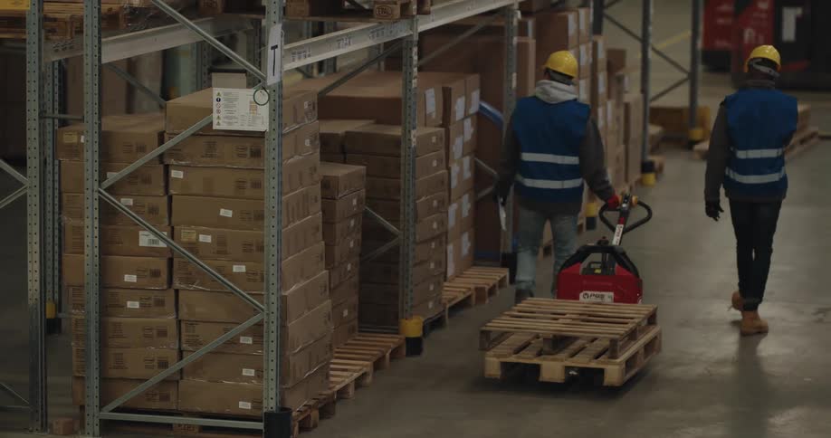 Two coworkers are working in a warehouse