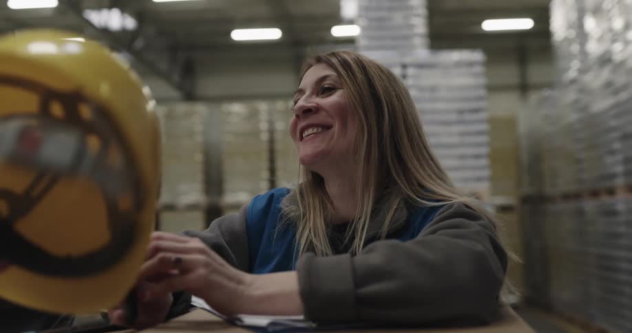 Group of coworkers talking and laughing at break time in the warehouse