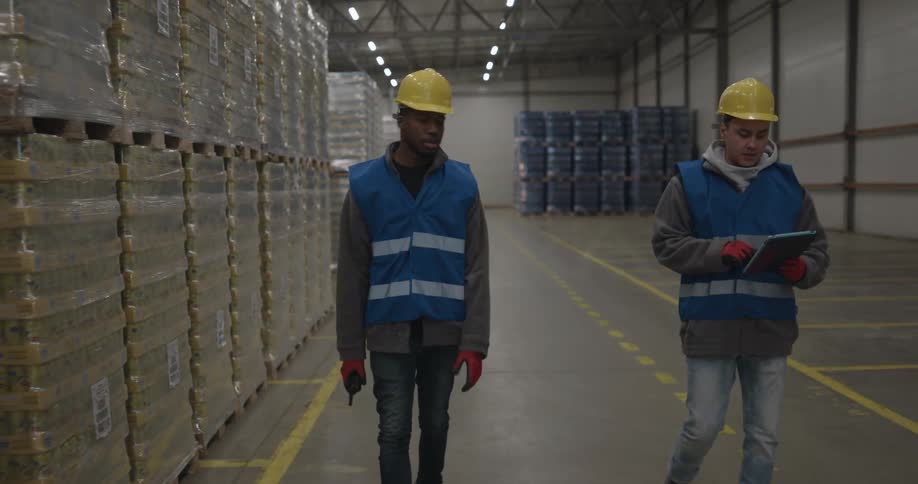 Two workers walking around a warehouse looking at things