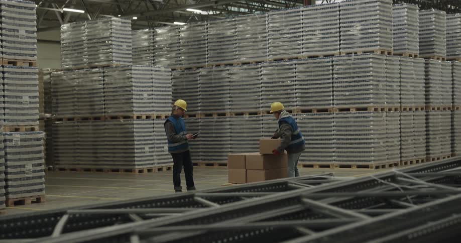 Three coworkers are lifting and carrying boxes