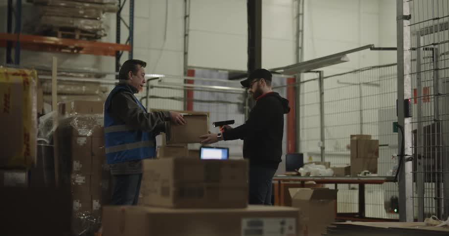 Warehouse worker delivering a box to a coworker