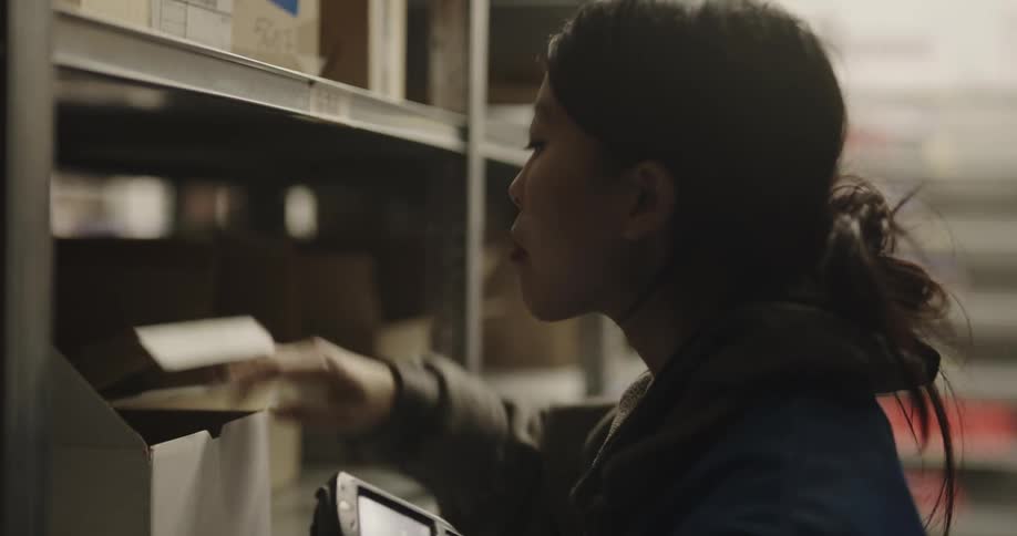 Warehouse employee scanning the barcode on the shelf with a scanner