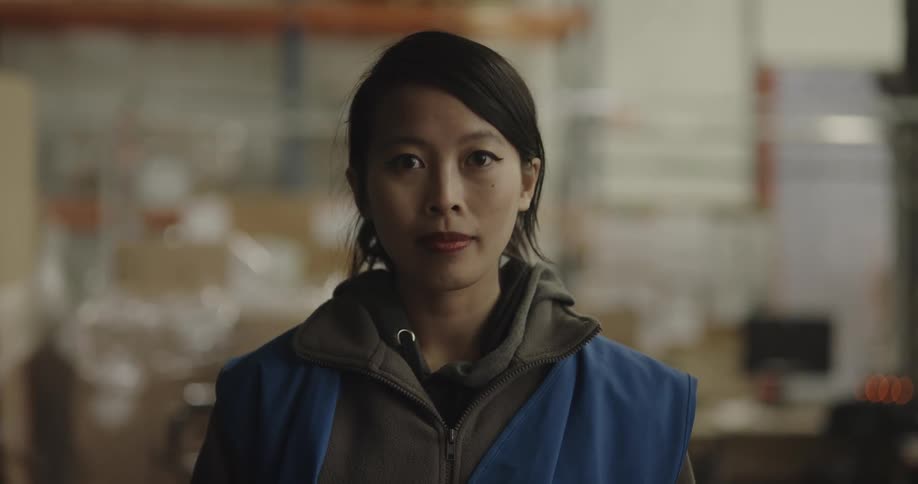 Warehouse worker faces the camera with eye contact in the warehouse
