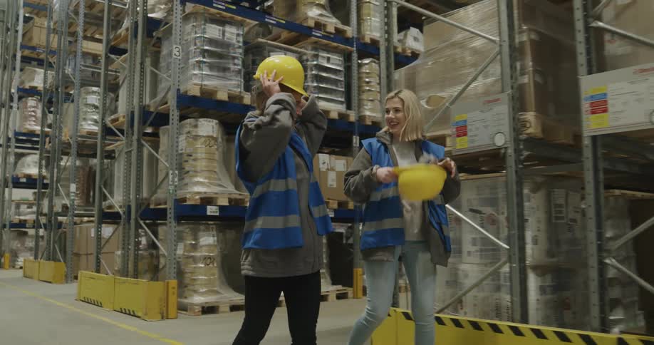Coworkers walking and talking on the aisles of a warehouse