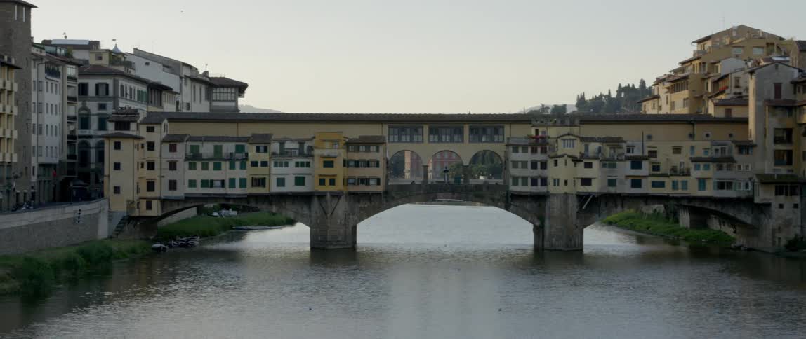 A bridge painted like buildings over a river