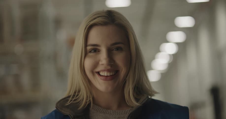 A woman in the warehouse smiles