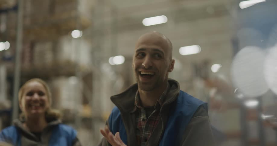 Two coworkers talking and laughing in a warehouse