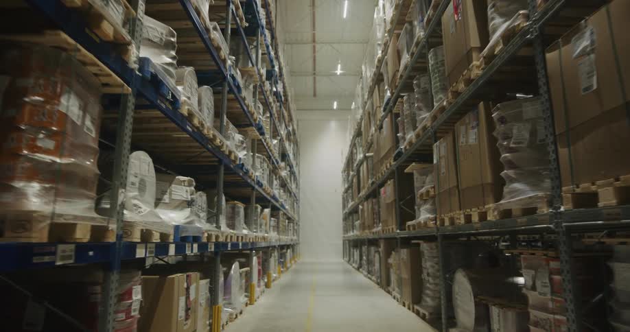 Pallets of products stored in the tall metal shelves inside a warehouse