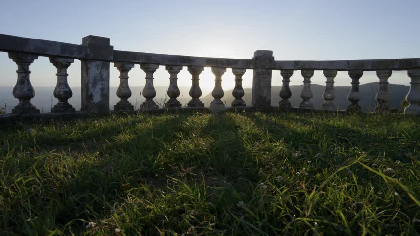 The sun shines through the decorative concrete fencing