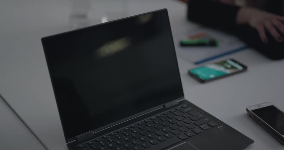Dark laptop next to smartphones on the table during a business meeting in the office
