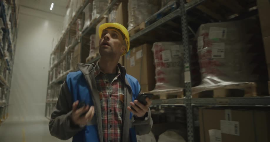 A man walking around a warehouse looking at things on shelves