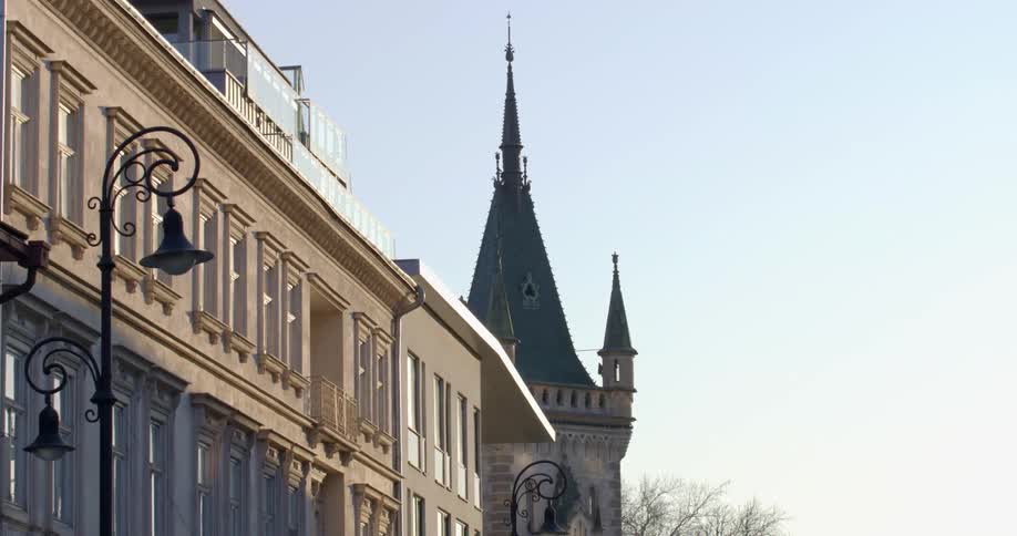 Ornate street lamps in front of a large building with a tower