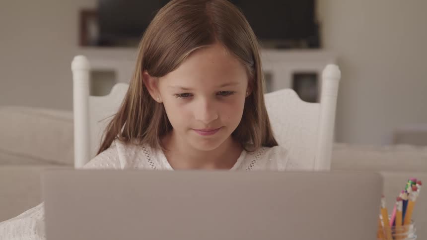 Girl sitting near jar full of pencil nods during online class