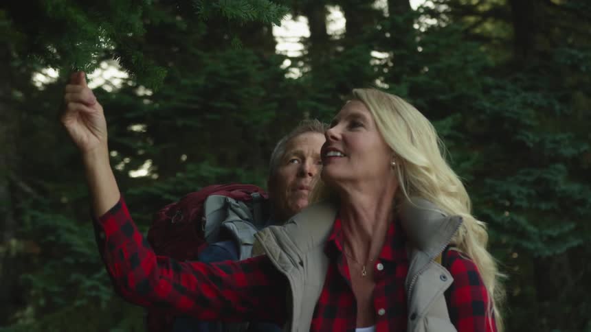 A man and woman hiking and looking at a tree
