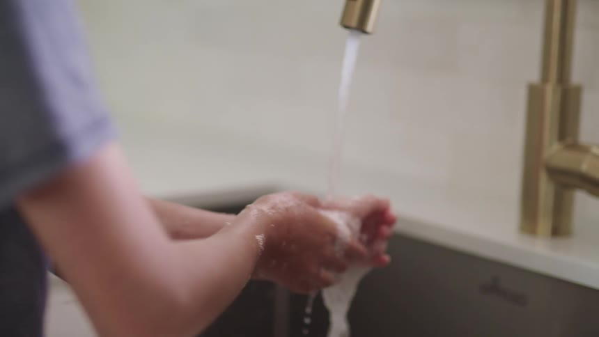 A person washing their hands with soap at home