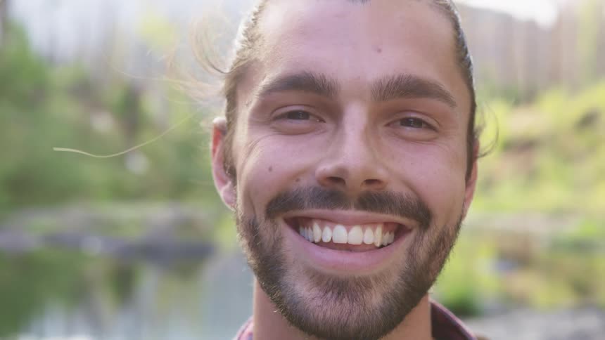 Man with beard and a pony tail faces the camera smilingly