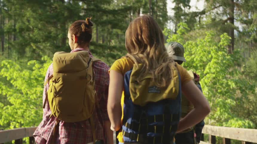 Three friends are outdoors hiking together